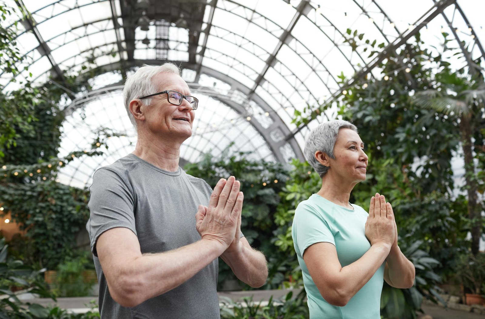 Senior couple enjoying a yoga session indoors, promoting harmony and healthy lifestyle.